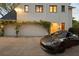 A three car garage adorned with greenery and a modern convertible in the driveway at 1016 Wildwood Ne Rd, Atlanta, GA 30306