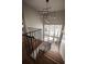 Modern staircase with black railings, wooden steps, and a unique chandelier, bathed in natural light from large windows at 1016 Wildwood Ne Rd, Atlanta, GA 30306