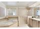 Bathroom featuring tub, large glass shower, window, and vanity with sink at 3711 Spinnaker Cir, Alpharetta, GA 30005
