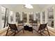 Sunroom with natural light, four woven chairs, and views of the lake and landscaping at 3711 Spinnaker Cir, Alpharetta, GA 30005