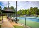 A blue and green tennis court featuring an awning-covered lounge area at 3711 Spinnaker Cir, Alpharetta, GA 30005