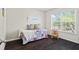 Cozy bedroom with wood floor, large window, and daybed at 512 Watercress Dr, Woodstock, GA 30188