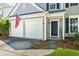 Close-up view of a charming two-story home with a two-car garage, American flag, and a 'Welcome' sign at 512 Watercress Dr, Woodstock, GA 30188