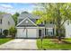 Charming two-story home featuring a two-car garage, manicured lawn, and mature tree in a suburban neighborhood at 512 Watercress Dr, Woodstock, GA 30188