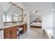 Bathroom with double vanity, marble floors, bathtub, large mirror, and Primary bedroom in background at 625 Park Creek Trce, Alpharetta, GA 30005