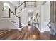 Elegant foyer with hardwood floors, staircase with white railings, and view into the living room at 625 Park Creek Trce, Alpharetta, GA 30005