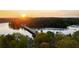 A scenic aerial view of the bridge and lake is highlighted by a radiant sunset backdrop at 6477 Old Shadburn Ferry Rd, Buford, GA 30518
