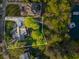 Aerial view of property featuring a large house, driveway, lake access, and lush greenery at 6477 Old Shadburn Ferry Rd, Buford, GA 30518