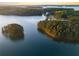Picturesque aerial view of a lake with wooded islands and winding roads along the shore at 6477 Old Shadburn Ferry Rd, Buford, GA 30518
