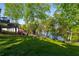 Expansive backyard featuring a lush lawn, mature trees, and a glimpse of the lake at 6477 Old Shadburn Ferry Rd, Buford, GA 30518