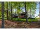 Rear view of the home highlighting the natural landscape and mature trees at 6477 Old Shadburn Ferry Rd, Buford, GA 30518
