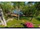 Lush backyard with mature trees, a manicured lawn, and a pathway leading to the waterfront at 6477 Old Shadburn Ferry Rd, Buford, GA 30518