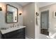 Stylish bathroom with a wood-trimmed mirror, modern vanity, and an open doorway to another room at 6477 Old Shadburn Ferry Rd, Buford, GA 30518