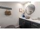 This is a sleek half bathroom featuring dark cabinets, a stone bowl sink, and stylish decor at 6477 Old Shadburn Ferry Rd, Buford, GA 30518