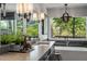 Bathroom with dual sink vanity, garden tub with a view, chandelier, and dark cabinets at 6477 Old Shadburn Ferry Rd, Buford, GA 30518