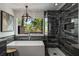 A luxurious bathroom featuring a soaking tub, glass shower, and a view of the trees outside the window at 6477 Old Shadburn Ferry Rd, Buford, GA 30518
