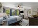 Comfortable bedroom featuring large windows, hardwood floors, a decorative ceiling fan, and soft, natural light at 6477 Old Shadburn Ferry Rd, Buford, GA 30518