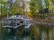 Lakeside property with a multi-slip boathouse, topped with loungers for relaxation at 6477 Old Shadburn Ferry Rd, Buford, GA 30518