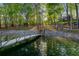 Private dock with a wooden walkway and stairs leading to the lake surrounded by lush trees at 6477 Old Shadburn Ferry Rd, Buford, GA 30518
