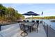 Dock featuring a dining table, chairs, and an umbrella overlooking the water at 6477 Old Shadburn Ferry Rd, Buford, GA 30518