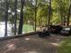 View of the driveway with a golf cart and parked cars next to the lake at 6477 Old Shadburn Ferry Rd, Buford, GA 30518