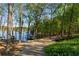 Scenic driveway leading to a waterfront home with boat docks and lush greenery at 6477 Old Shadburn Ferry Rd, Buford, GA 30518