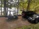 View of the driveway with a golf cart and parked cars next to the lake at 6477 Old Shadburn Ferry Rd, Buford, GA 30518