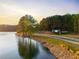 Inviting entrance to the community by the lake with beautiful landscaping and signage at 6477 Old Shadburn Ferry Rd, Buford, GA 30518