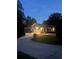 Charming single-story home with manicured lawn, paved driveway and attached garages at dusk at 6477 Old Shadburn Ferry Rd, Buford, GA 30518