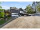 Rear exterior view of the home featuring a three-car garage and multiple decks with scenic views at 6477 Old Shadburn Ferry Rd, Buford, GA 30518