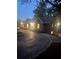 Charming single-story home with manicured lawn, dark siding and paved driveway at dusk at 6477 Old Shadburn Ferry Rd, Buford, GA 30518