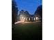 Charming single-story home with manicured lawn, paved driveway and attached garages at dusk at 6477 Old Shadburn Ferry Rd, Buford, GA 30518
