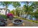 Cozy stone firepit area with Adirondack chairs, set against a backdrop of mature trees and lake views at 6477 Old Shadburn Ferry Rd, Buford, GA 30518