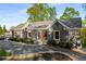 Beautiful home exterior showing landscaping, shutters, and a driveway that leads to a golf cart at 6477 Old Shadburn Ferry Rd, Buford, GA 30518
