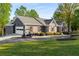 Charming exterior featuring a well-maintained lawn, a golf cart, and a convenient attached garage at 6477 Old Shadburn Ferry Rd, Buford, GA 30518