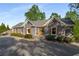 Beautiful house with a driveway, mature trees, and a golf cart on the side at 6477 Old Shadburn Ferry Rd, Buford, GA 30518