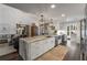 Open-concept kitchen with an eat-in island, flows into a living space, and features stainless steel appliances at 6477 Old Shadburn Ferry Rd, Buford, GA 30518