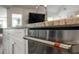 Close up of kitchen island, stainless steel dishwasher with matching hardware, and granite countertops at 6477 Old Shadburn Ferry Rd, Buford, GA 30518