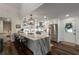 Open kitchen with large island, stainless steel appliances, and modern lighting fixtures at 6477 Old Shadburn Ferry Rd, Buford, GA 30518