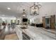 Stylish open-concept kitchen featuring a marble island, pendant lighting, and stainless steel appliances at 6477 Old Shadburn Ferry Rd, Buford, GA 30518