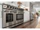 Stainless steel Thor range in kitchen with white cabinets and a stainless steel refrigerator at 6477 Old Shadburn Ferry Rd, Buford, GA 30518