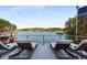 Relaxing lake view from the deck featuring lounge chairs, railing, and a tranquil waterfront scene at 6477 Old Shadburn Ferry Rd, Buford, GA 30518
