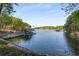 Calm lake view showcasing a private dock with boat lifts and lush surroundings at 6477 Old Shadburn Ferry Rd, Buford, GA 30518