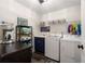 This is a well-organized laundry room with a washer, dryer, utility sink, and storage shelves at 6477 Old Shadburn Ferry Rd, Buford, GA 30518