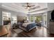 Inviting primary bedroom with a large bed, hardwood floors, ample lighting, and a sitting area overlooking the backyard at 6477 Old Shadburn Ferry Rd, Buford, GA 30518