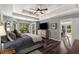Spacious main bedroom with tray ceilings, windows, and a door leading to an outdoor deck at 6477 Old Shadburn Ferry Rd, Buford, GA 30518