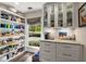 Pantry features open shelving, cabinetry, drawers, marble countertop, and view to back yard at 6477 Old Shadburn Ferry Rd, Buford, GA 30518