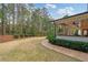 A large backyard with lush lawn, mature trees, and covered patio perfect for entertaining at 1010 Lake Shore Overlook, Alpharetta, GA 30005
