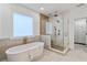 Luxurious bathroom with a freestanding tub, walk-in glass shower with rain head, and access to a walk-in closet at 1010 Lake Shore Overlook, Alpharetta, GA 30005