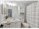 Well-lit bathroom featuring a sink vanity, mirror, toilet, and shower with patterned curtain at 1010 Lake Shore Overlook, Alpharetta, GA 30005